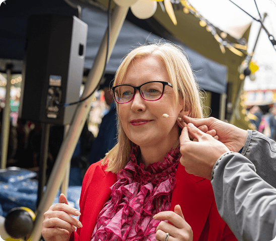 Coach having a microphone fitted before speaking at an event